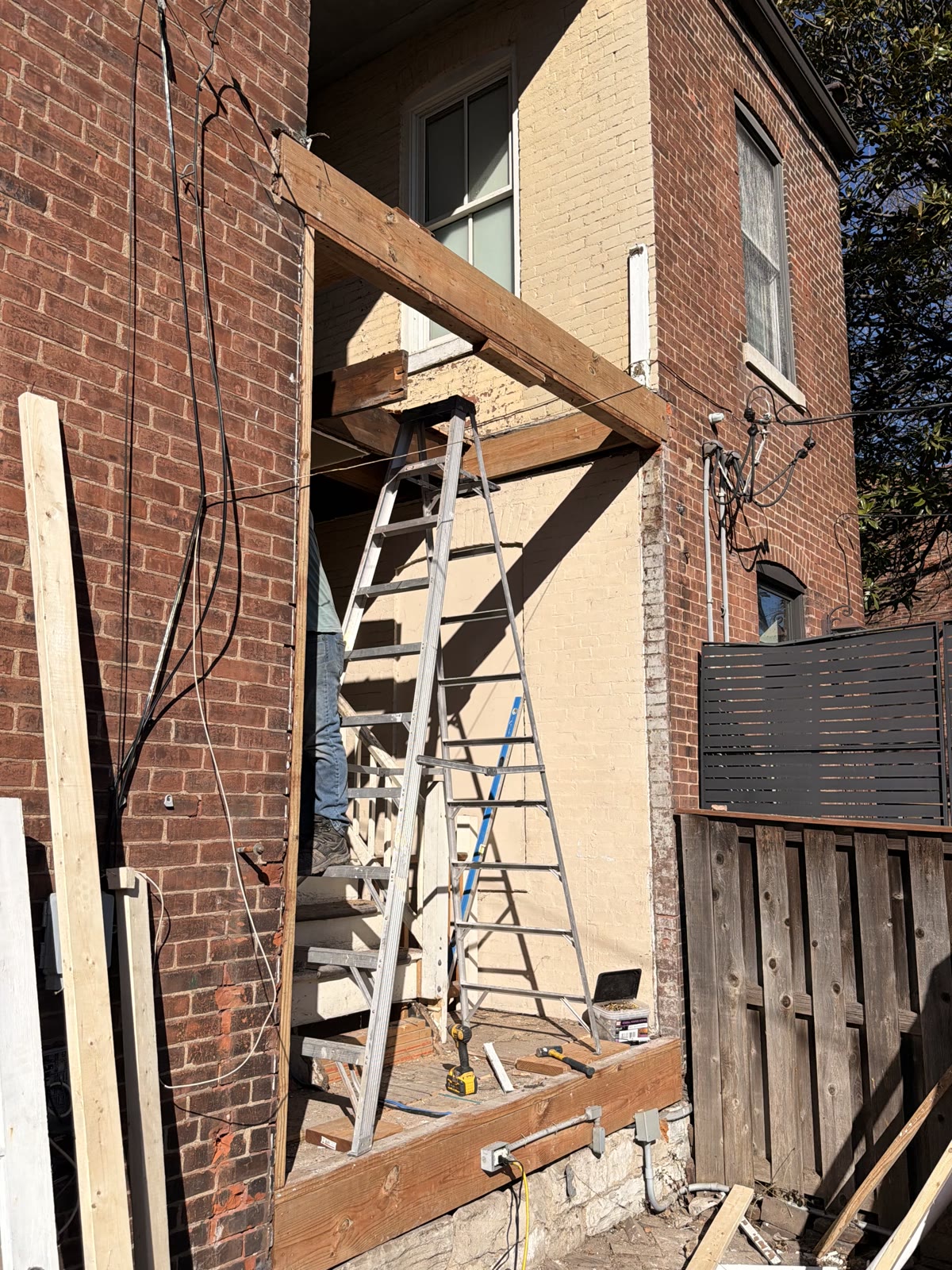 Exterior brick wall with newly framed window opening during a structural repair