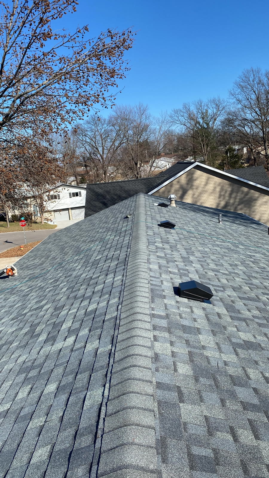 Completed gray architectural shingle roof with new vent boots