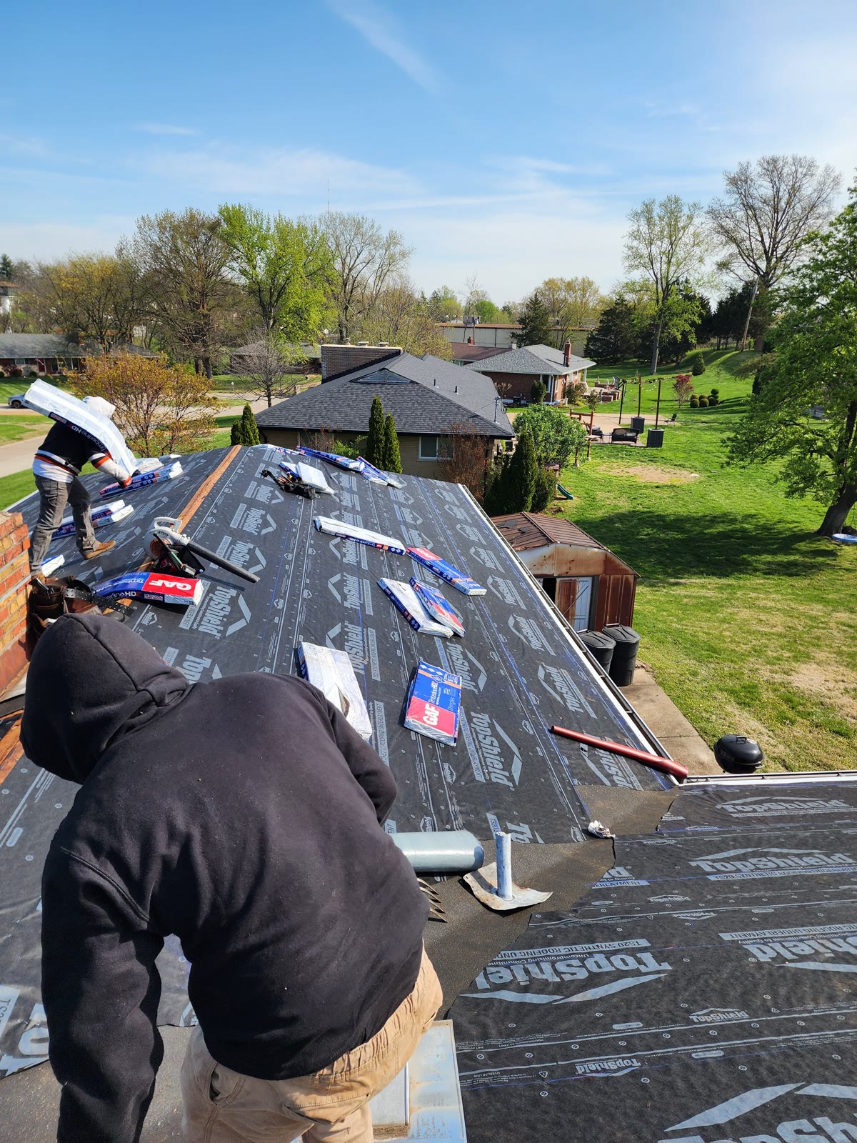 LJC crew laying synthetic roofing underlayment on a residential roof