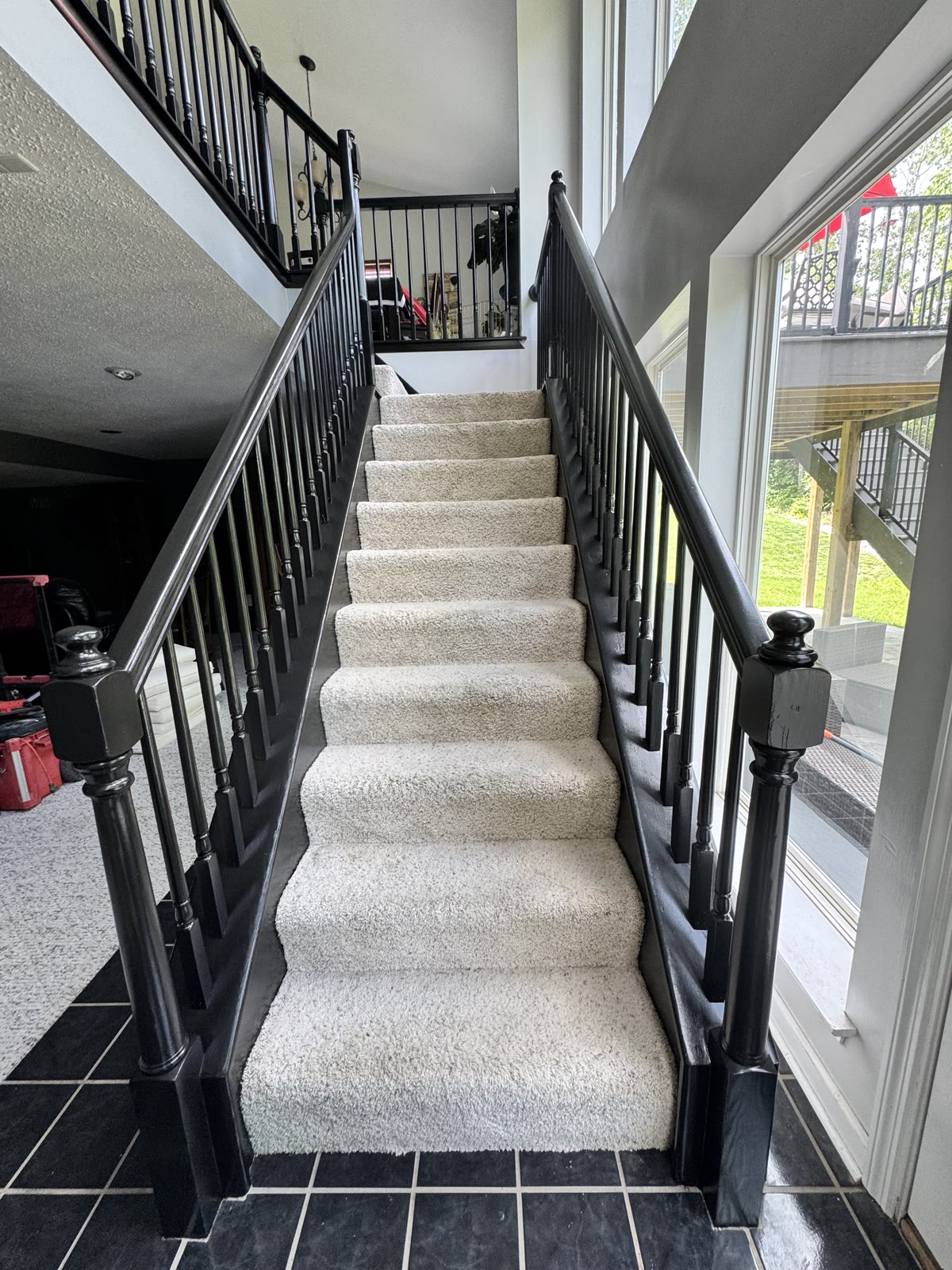 Black iron stair railing with carpet treads, detailed view