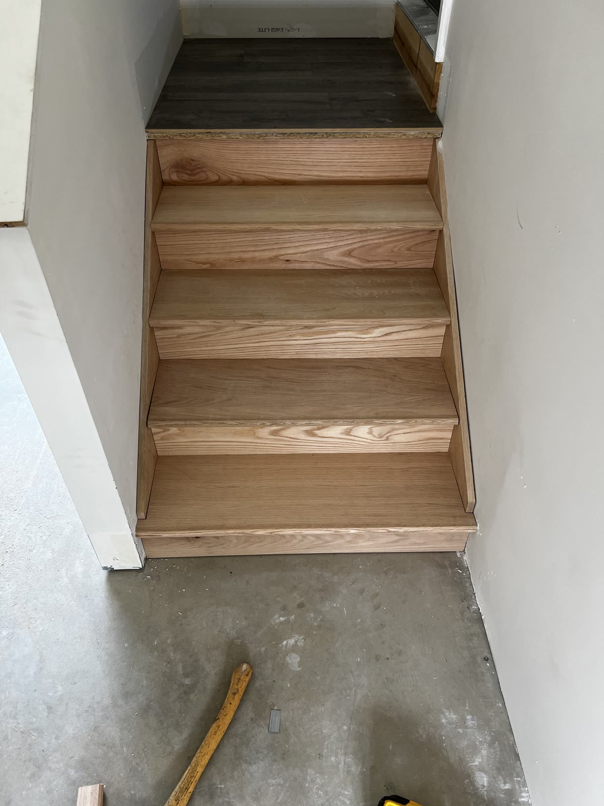Newly installed unfinished oak stair treads and risers